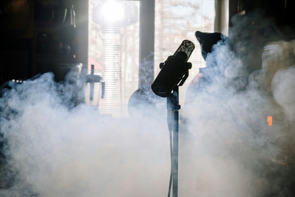 A mysterious microphone stands amidst swirling smoke in a sunlit home studio.