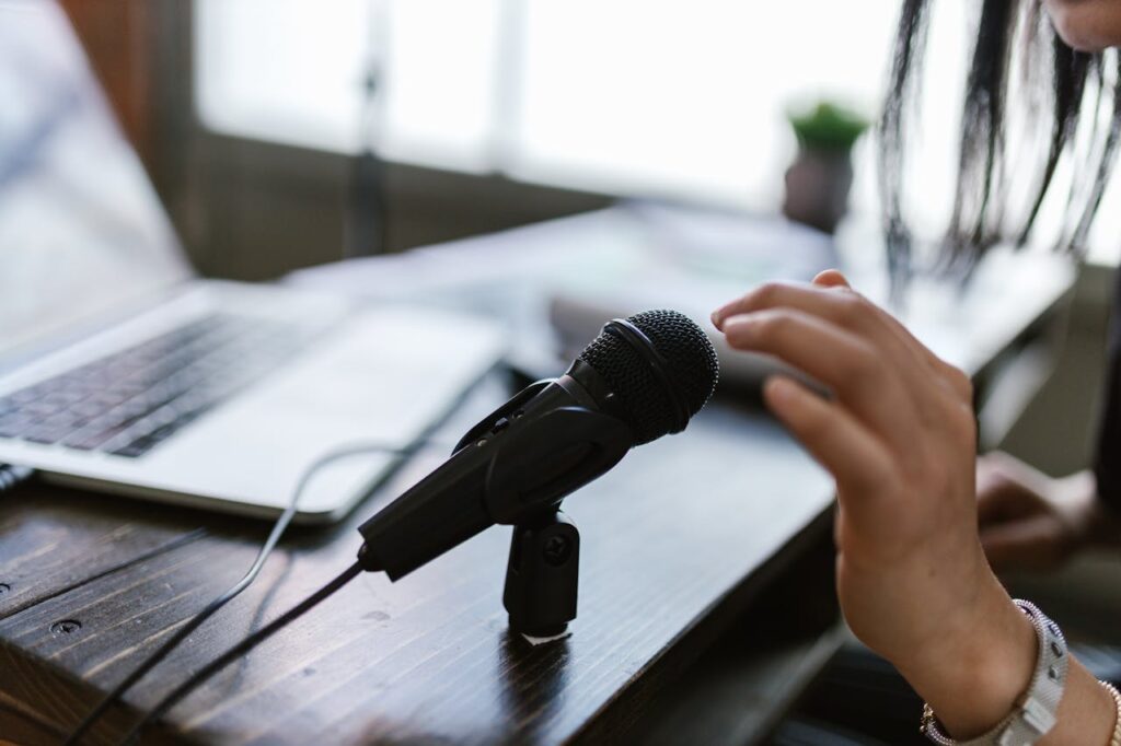 Crafting Captivating Headlines: Your awesome post title goes here Close-up of a microphone and hand near a laptop, ideal for podcasting themes.